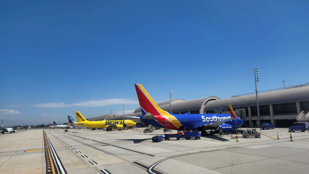 Planes painted in different colors standing at airport gates.